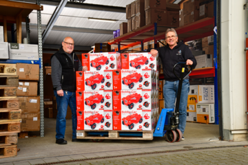 Mitarbeiter vor Palette mit Bobby Cars im Lager